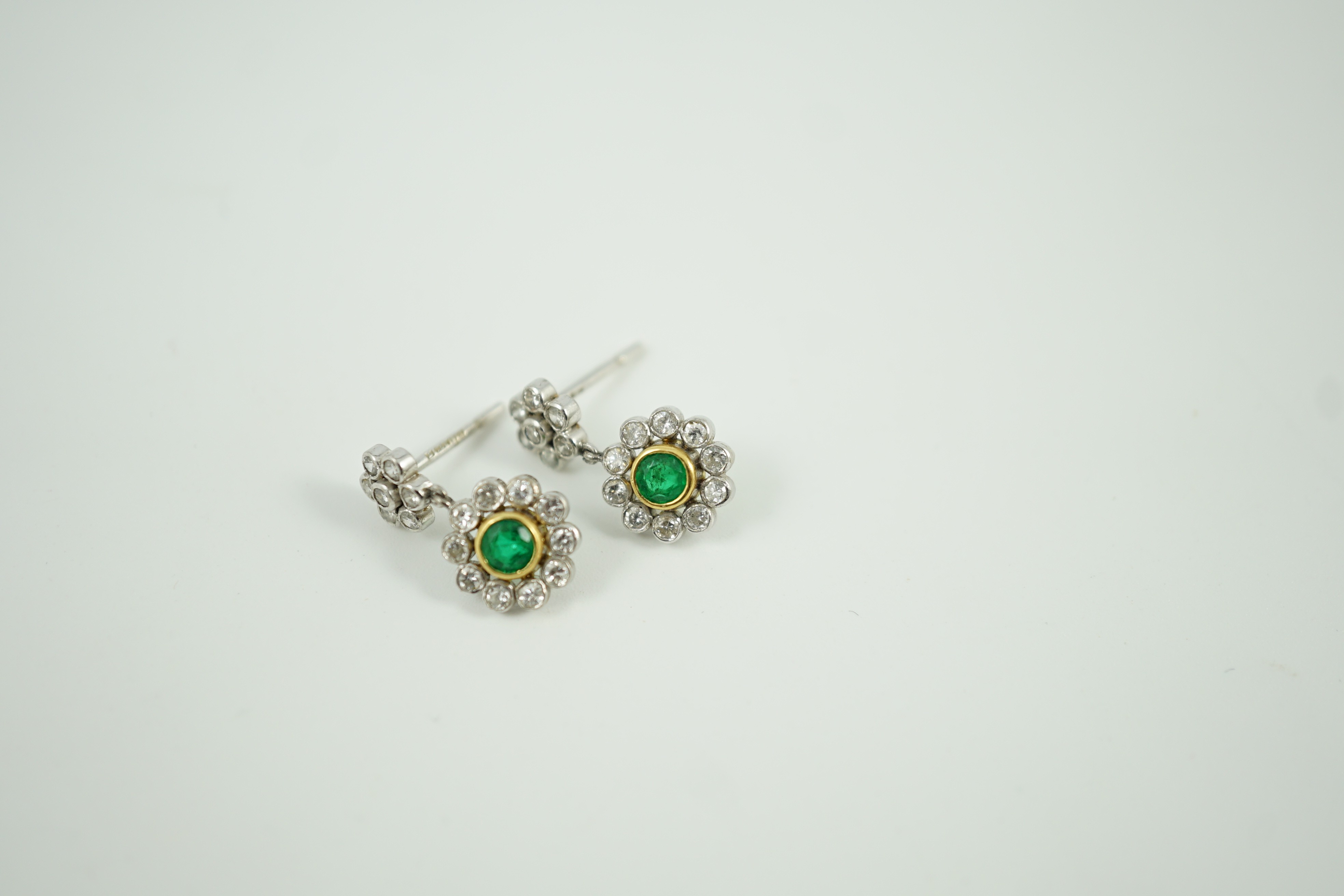 A modern pair of 18ct white gold, emerald and diamond cluster set drop earrings, 16mm, gross weight 3 grams.